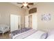 Bedroom with ceiling fan, white furniture, and a closet with mirrored doors at 301 E Ashurst Dr, Phoenix, AZ 85048