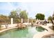 An inviting backyard pool with a rock waterfall and desert landscaping offering a serene escape at 301 E Ashurst Dr, Phoenix, AZ 85048