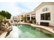 Backyard pool with rock waterfall feature, lounge chairs, and views of the home's outdoor living space at 301 E Ashurst Dr, Phoenix, AZ 85048