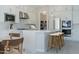 Bright kitchen features white cabinetry, stainless steel appliances, center island with stools, and decorative backsplash at 37765 W Santa Maria St, Maricopa, AZ 85138