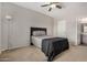 Bedroom with neutral colors, ceiling fan, and door leading into the en-suite bathroom at 3830 E Lakewood Pkwy # 3164, Phoenix, AZ 85048