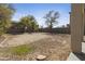 View of the backyard featuring sparse landscaping, dirt, and a block wall fence at 3911 S 100Th Gln, Tolleson, AZ 85353