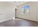 Bedroom with neutral walls, dark floors, and a window with clear views to the outdoors at 3911 S 100Th Gln, Tolleson, AZ 85353