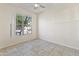 Bright, empty bedroom with tile floors, a ceiling fan, and a large window offering natural light at 3911 S 100Th Gln, Tolleson, AZ 85353