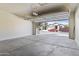 Spacious garage with an open garage door, revealing the front of the house and cars parked in the driveway at 3911 S 100Th Gln, Tolleson, AZ 85353