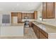 Well-lit kitchen featuring tile floors, an island, granite counters, and sleek stainless steel appliances at 3911 S 100Th Gln, Tolleson, AZ 85353