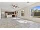 Bright open-plan living room with tile floors, a ceiling fan, and seamless flow to the adjacent kitchen at 3911 S 100Th Gln, Tolleson, AZ 85353