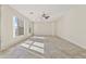 Spacious living room featuring tile flooring, large windows providing ample natural light, and a ceiling fan at 3911 S 100Th Gln, Tolleson, AZ 85353