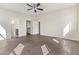 Primary bedroom with dark wood-look flooring, neutral walls, ceiling fan and ensuite bath at 3911 S 100Th Gln, Tolleson, AZ 85353