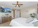 Well-lit bedroom featuring a ceiling fan, TV, and a sliding barn door to the en-suite bathroom at 4077 S Sabrina Dr # 23, Chandler, AZ 85248