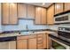 Kitchen with stainless steel appliances, wooden cabinets, and a tile backsplash at 4354 N 82Nd St # 182, Scottsdale, AZ 85251