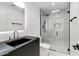 Modern bathroom showcasing a black vanity, marble shower, and glass door, complete with sleek, contemporary fixtures at 4825 N 72Nd Way, Scottsdale, AZ 85251