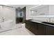 Modern bathroom featuring marble walls, a freestanding tub, and a sleek vanity with dual sinks and illuminated mirror at 4825 N 72Nd Way, Scottsdale, AZ 85251