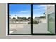 View of the neighborhood showcasing buildings, palm trees, and a blue sky from a window with a black frame at 4825 N 72Nd Way, Scottsdale, AZ 85251