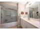 Cozy bathroom featuring a tub and shower combination and a vanity with a sink and a large mirror at 5429 N 78Th St, Scottsdale, AZ 85250