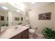 Bathroom featuring a marble vanity, framed mirror, toilet and artistic decor at 5429 N 78Th St, Scottsdale, AZ 85250