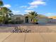 Charming single-story home featuring desert landscaping, a two-car garage, and mature palm trees at 573 W Rattlesnake Pl, Casa Grande, AZ 85122