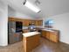 Well-lit kitchen featuring modern appliances, tile flooring, and an island at 573 W Rattlesnake Pl, Casa Grande, AZ 85122