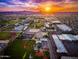 Expansive aerial view showcases the property's desirable location with distant mountains and a vibrant community at sunset at 6018 N 32Nd Ave, Phoenix, AZ 85017