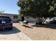 Modest home featuring a sandy front yard with mature shade tree, grill, and driveway parking at 6018 N 32Nd Ave, Phoenix, AZ 85017