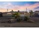 Charming single-story home with a minimalist rock garden in the front yard at dusk at 6627 W Keim Dr, Glendale, AZ 85301