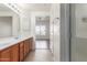 Bathroom with dual sinks, wood cabinets, and a glass-enclosed shower at 6770 N 47Th Ave # 1022, Glendale, AZ 85301