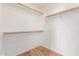 Empty walk-in closet with white walls and wood shelves and floor at 6770 N 47Th Ave # 1022, Glendale, AZ 85301