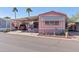 Charming manufactured home has a carport, desert landscaping, and beautiful palm trees in the background at 701 S Dobson Rd # 432, Mesa, AZ 85202