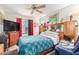 This bedroom features a ceiling fan, red curtains and integrated headboard storage at 8429 W Vernon Ave, Phoenix, AZ 85037