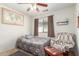 Cozy bedroom with a ceiling fan, natural light from a window, and colorful accents at 8429 W Vernon Ave, Phoenix, AZ 85037