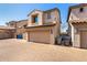 Two-story townhome with a tan stucco exterior, tile roof, and a two car garage at 8429 W Vernon Ave, Phoenix, AZ 85037