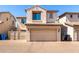 Two-story townhome with a tan stucco exterior, tile roof, and a two car garage at 8429 W Vernon Ave, Phoenix, AZ 85037