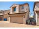 Two-story townhome with a tan stucco exterior, tile roof, and a two car garage at 8429 W Vernon Ave, Phoenix, AZ 85037