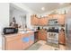 Well-lit kitchen with wood cabinets, stainless steel appliances, and tile flooring at 8429 W Vernon Ave, Phoenix, AZ 85037