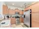 Bright kitchen with wood cabinetry, stainless steel appliances, and tile flooring at 8429 W Vernon Ave, Phoenix, AZ 85037