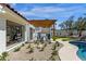 Backyard features a cozy outdoor kitchen under a wooden pergola with a freeform pool and professional landscaping at 10013 N 106Th Pl, Scottsdale, AZ 85258