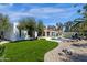 Expansive backyard with a freeform pool, mature landscaping, and an outdoor kitchen under a pergola at 10013 N 106Th Pl, Scottsdale, AZ 85258