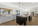 Open kitchen with large center island, bar seating, and a view to the backyard at 10013 N 106Th Pl, Scottsdale, AZ 85258
