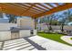 Beautiful outdoor kitchen with stainless steel grill and wood pergola that provides shade at 10013 N 106Th Pl, Scottsdale, AZ 85258