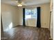 Comfortable bedroom features wood-look floors and window with curtains at 11108 W Cameo Dr, Sun City, AZ 85351