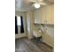Functional laundry room with ample storage, a utility sink, and modern wood-look flooring at 11108 W Cameo Dr, Sun City, AZ 85351