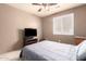 Cozy bedroom featuring neutral tones, a ceiling fan, and a comfortable bed and white window shutter at 12622 W Catalina Dr, Avondale, AZ 85392