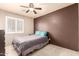 Bright bedroom with a contrasting accent wall, ceiling fan and plantation shutters at 12622 W Catalina Dr, Avondale, AZ 85392