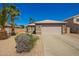 Charming single-story home with a two car garage and desert landscaping with beautiful palm trees at 12622 W Catalina Dr, Avondale, AZ 85392