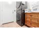 Efficient laundry area with stacked washer and dryer, paired with a dresser for storage at 12622 W Catalina Dr, Avondale, AZ 85392