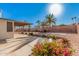 Spacious backyard with a covered patio, desert landscaping, pink flowers, and palm trees at 13008 N 28Th Pl, Phoenix, AZ 85032