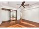 Generous bedroom featuring hardwood floors, a ceiling fan, and a mirrored closet for added depth at 13008 N 28Th Pl, Phoenix, AZ 85032