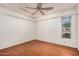 Bedroom featuring wood floors, a ceiling fan with spotlights, a window offering outside views, and neutral walls at 13008 N 28Th Pl, Phoenix, AZ 85032