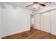 This bedroom includes wood floors, neutral walls, a ceiling fan, and a closet with sliding doors at 13008 N 28Th Pl, Phoenix, AZ 85032