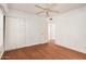 Bright bedroom featuring wood floors, neutral walls, a ceiling fan, and a closet with sliding doors at 13008 N 28Th Pl, Phoenix, AZ 85032
